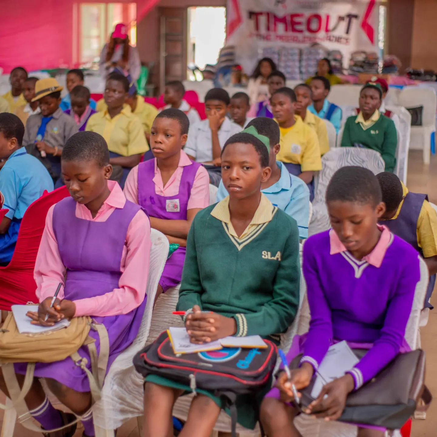 Girls listening and taking notes at a Peerless Network conference
