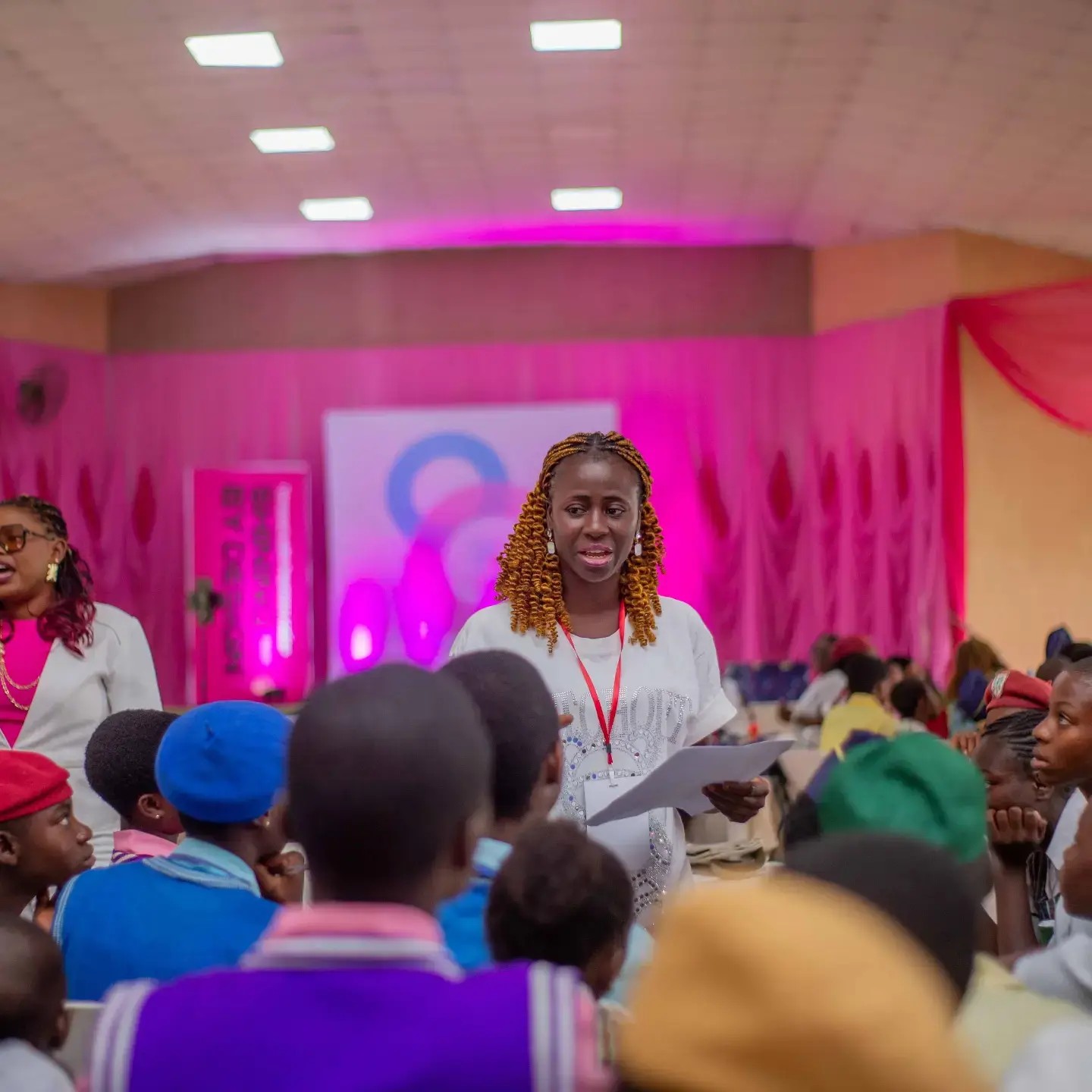 A facilitator speaking with seated participants at the Peerless conference