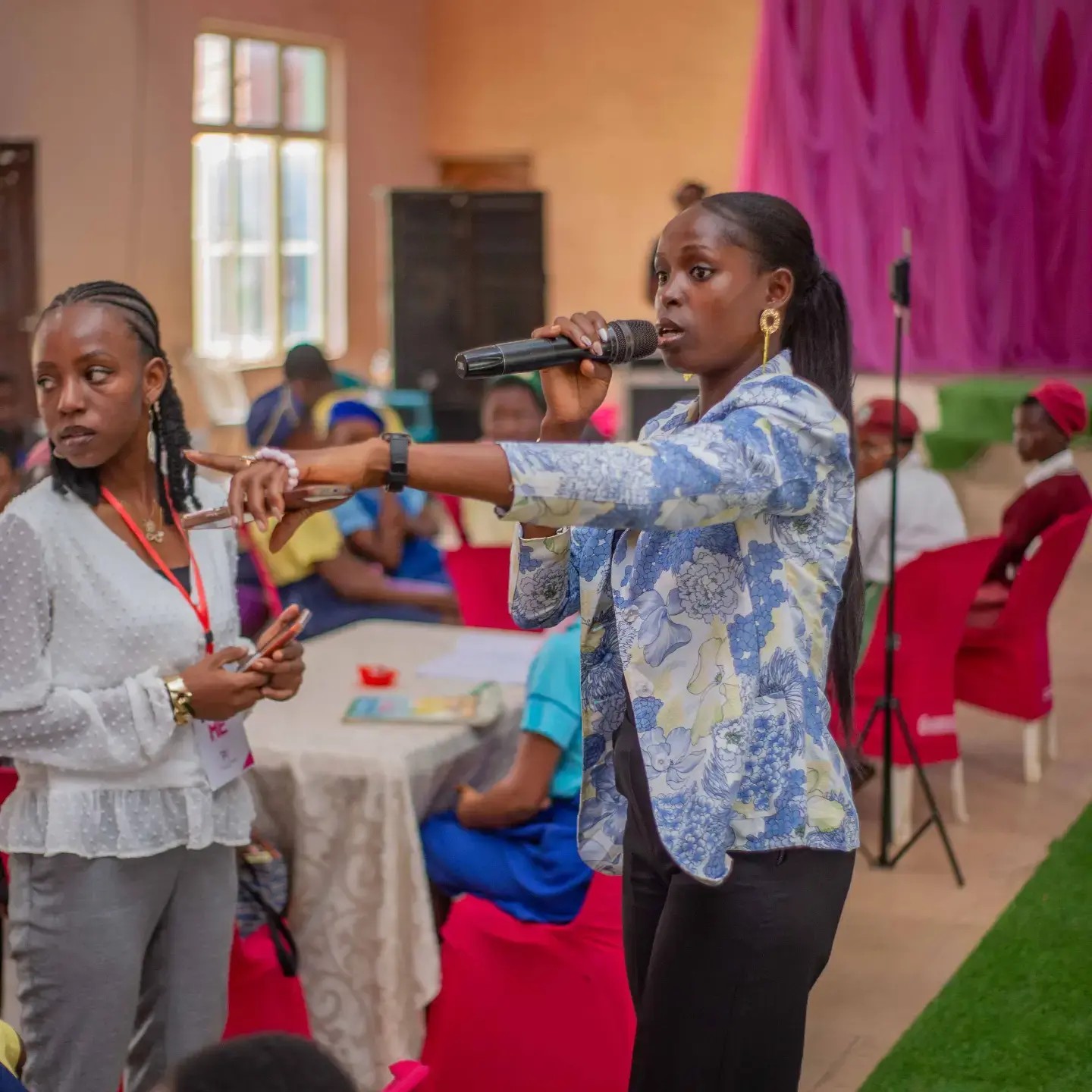 A girl speaking into a microphone during a Peerless discussion